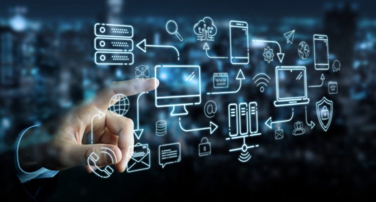 Verschiedene Piktogramme, die ein IT-Netzwerk symbolisieren, sind auf einer Ebene angeordnet – mit einer Hand im Hintergrund, die auf eines der Symbole deutet.