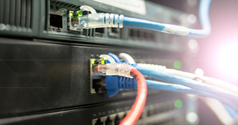 Nahaufnahme eines Netzwerk-Panels mit grünen Leuchtdioden sowie mit blauen und roten Kabeln