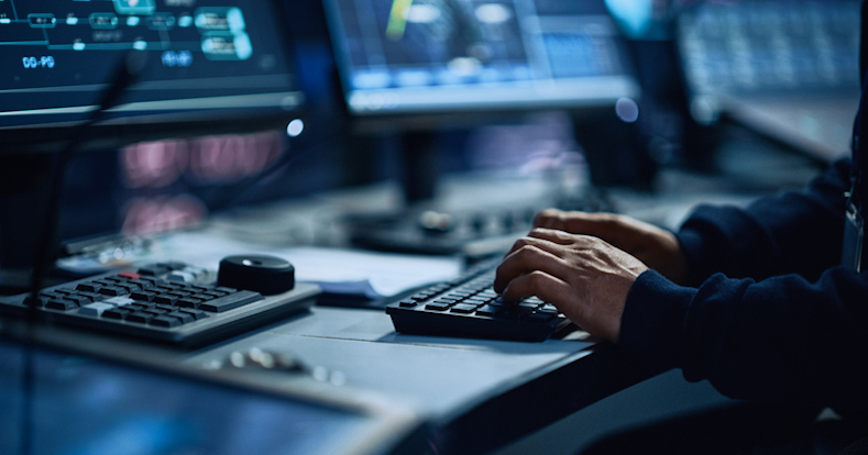 Close de um especialista de escritório profissional trabalhando no computador desktop na moderna sala de controle de monitoramento tecnológico com telas digitais. Gerente digitando no teclado e usando o mouse.