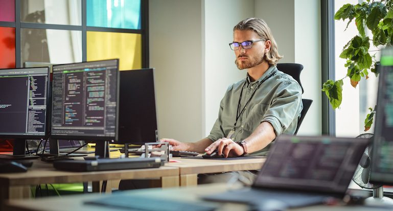 Male Data Scientist Coding on Desktop Computer